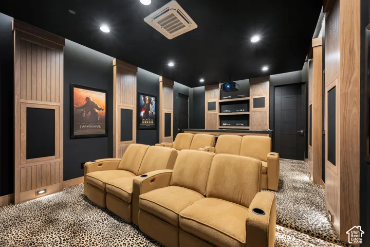 Dedicated entertainment space featuring a black ceiling, recessed lighting, and wood-paneled walls