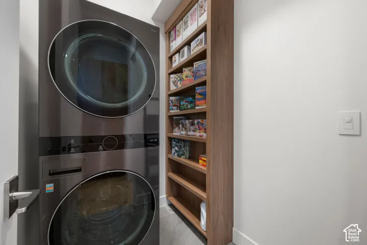 Stackable laundry unit with front-loading doors, light wood-finish shelving, and white walls