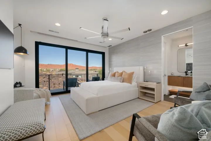 Hardwood-style flooring, expansive sliding glass doors, contemporary ceiling fan, recessed lighting, and an attached bath with a floating vanity