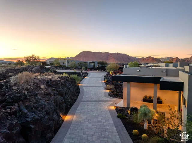 Paver driveway with integrated lighting, desert landscaping, and mountain backdrop