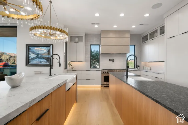 Gourmet kitchen with double islands, two farmhouse sinks, stainless steel appliances, and wood-finish cabinetry