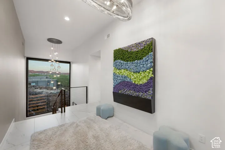 Large window with exterior scenery, modern chandelier, recessed lighting, and tile flooring