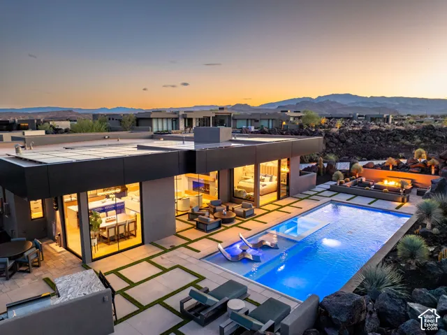 Modern exterior with expansive glass walls, a rectangular swimming pool, and an integrated spa