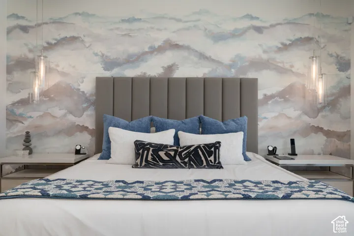 Accent wall with abstract mural, upholstered headboard, and two pendant light fixtures