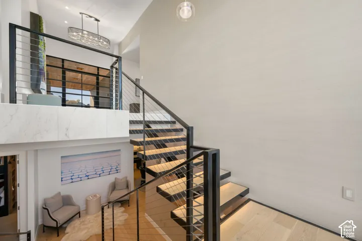 Floating staircase featuring wood-finish treads and cable railings