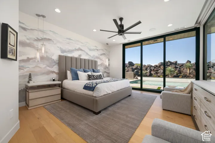 Hardwood-finish flooring, accent wall, recessed lighting, ceiling fan, and expansive sliding glass doors