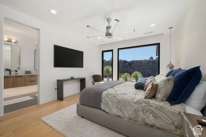 Light wood-finish flooring, recessed ceiling lighting, a modern ceiling fan, and large windows with black frames