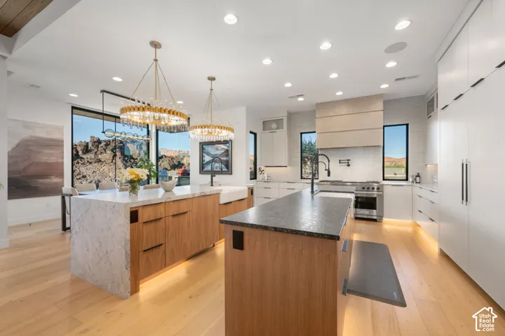 Double kitchen islands, full-height windows, recessed lighting, wood-finish flooring, and integrated appliances