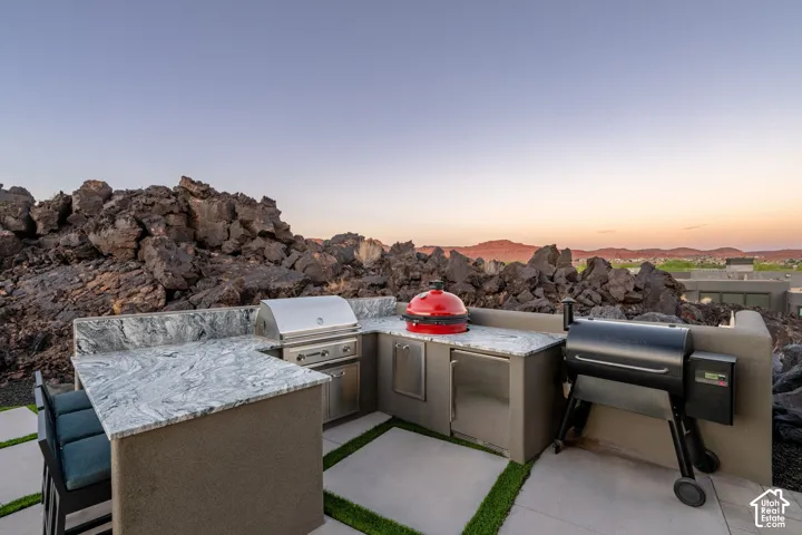 Outdoor kitchen with integrated stainless steel grill, beverage refrigerator, and expansive countertop space