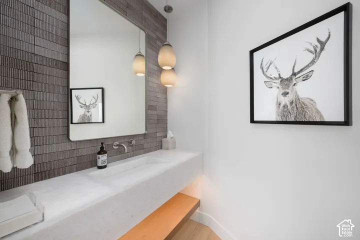 Modern vanity with integrated sink, wall-mounted faucet, and under-counter wooden shelf