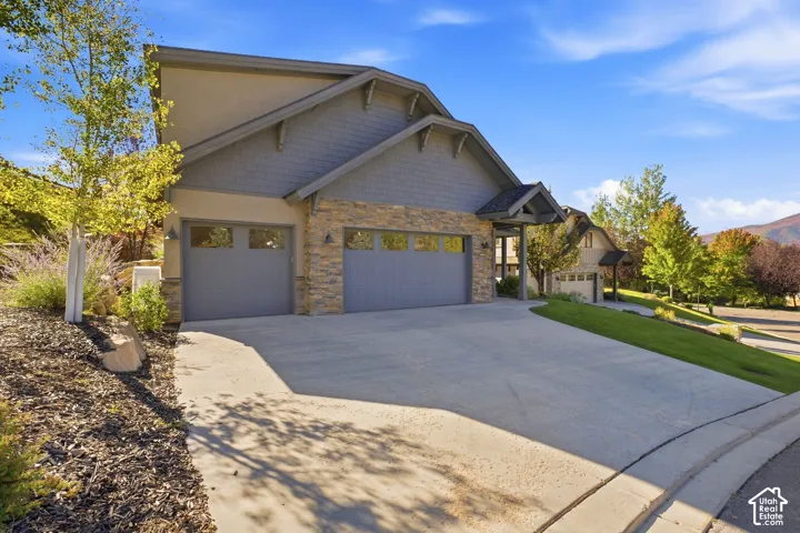 Contemporary exterior featuring stacked stone and shingle siding accents
