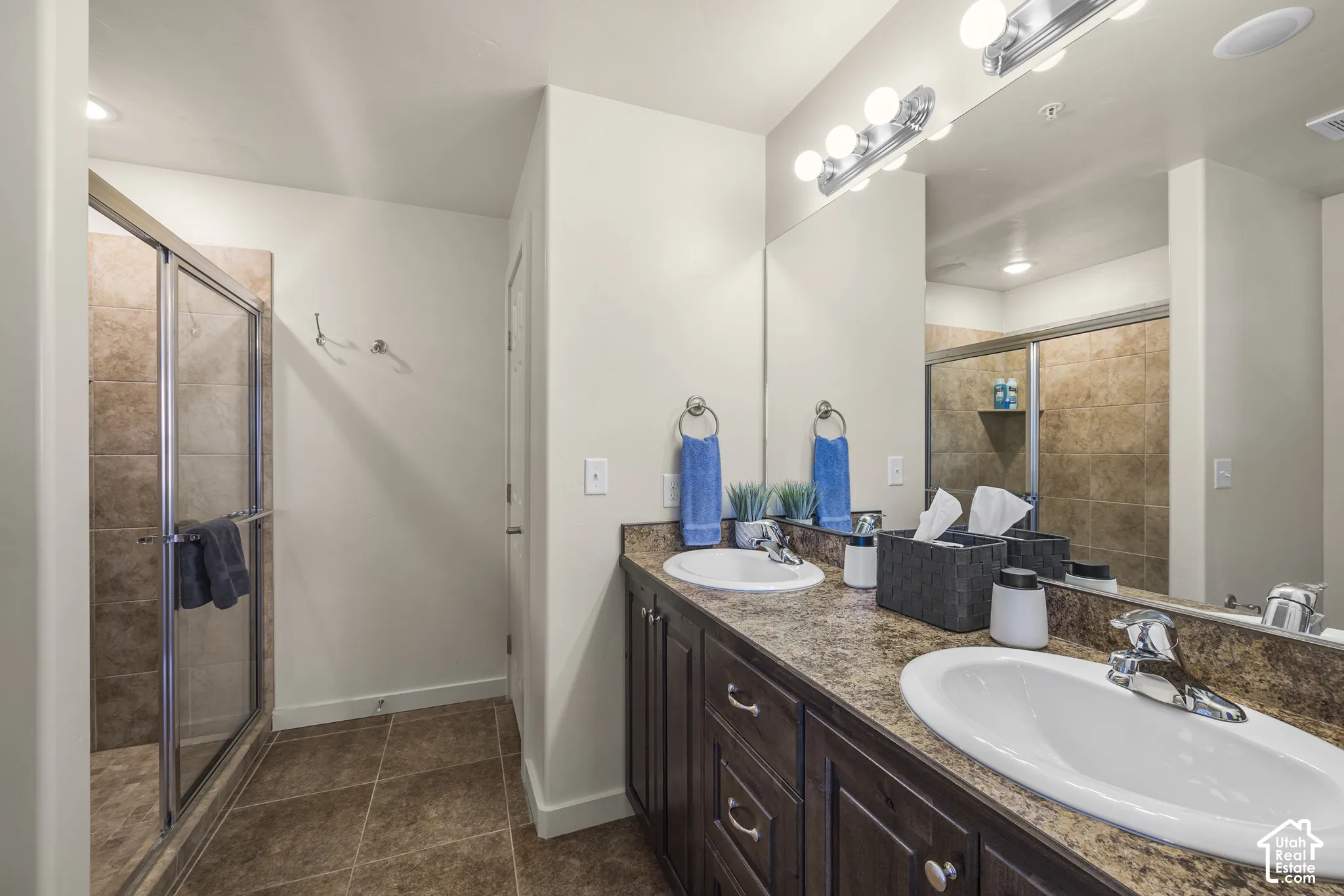Double vanity with undermount sinks, chrome fixtures, and a speckled countertop