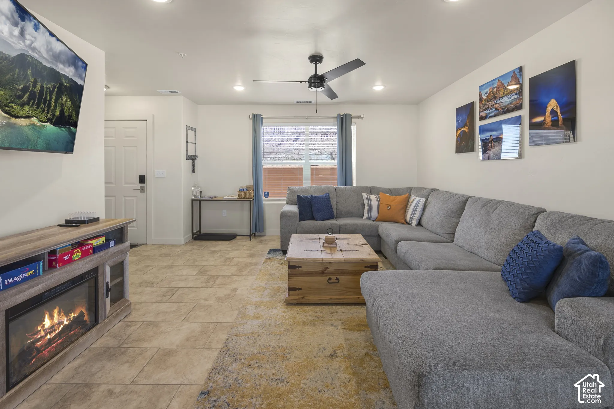 Recessed lighting, ceiling fan, tile flooring, and a built-in media console with an electric fireplace