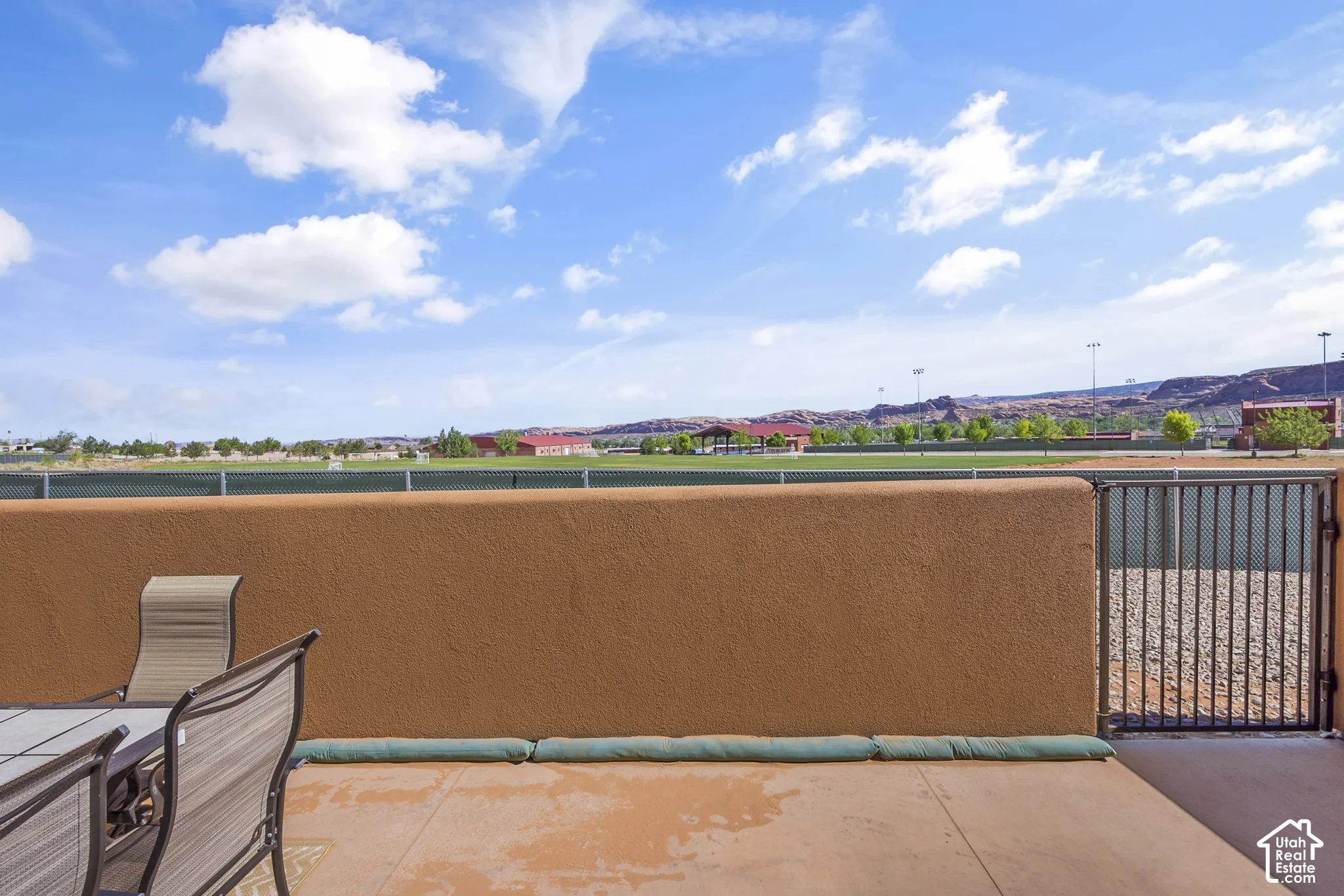 Private patio with a stucco wall and a black metal gate
