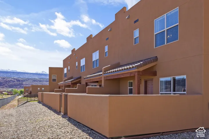 Southwestern-style exterior with stucco finish, multiple windows, and a tiled entry canopy