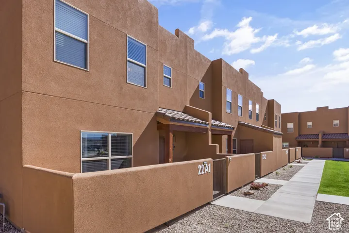 Stucco exterior with multiple windows, covered entry, and tile roof accents