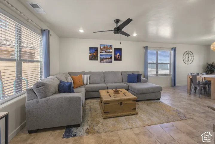 Recessed lighting, ceiling fan, large windows with blinds, and tile flooring