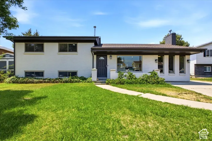 White stucco exterior with dark trim and a prominent front entry
