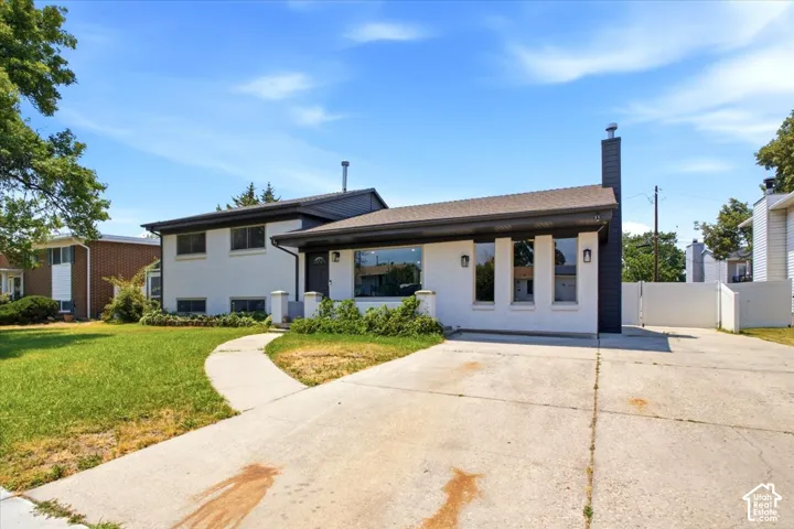White exterior with dark trim and a prominent dark chimney