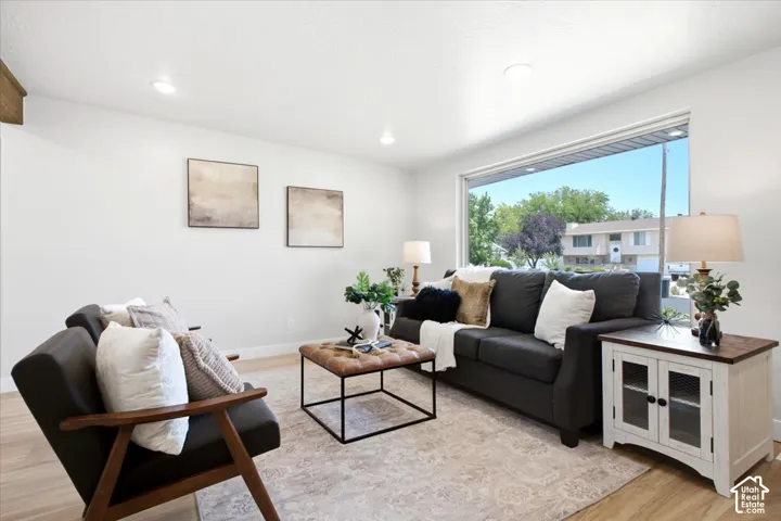Expansive picture window, recessed lighting, wood-finish flooring, and crisp white walls