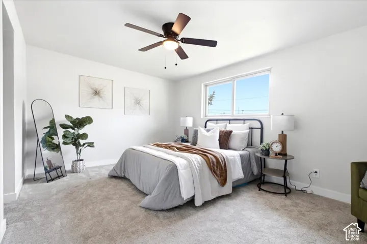 Recessed window with white trim, light neutral carpet, ceiling fan with light fixture, and white painted walls