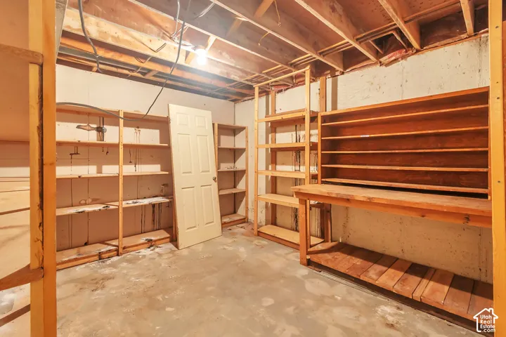 Exposed wood ceiling joists, wood shelving units, and a wood workbench with built-in storage