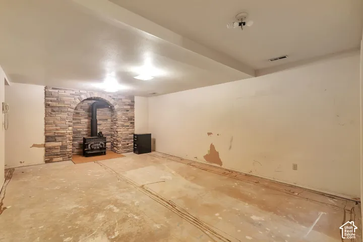 Arched stone-face fireplace with a freestanding wood-burning stove