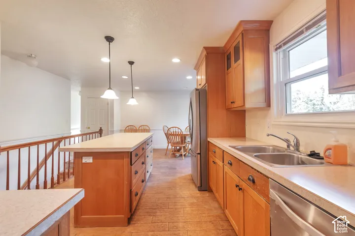 Kitchen with wood-finish flooring, light wood cabinetry, and stainless steel appliances