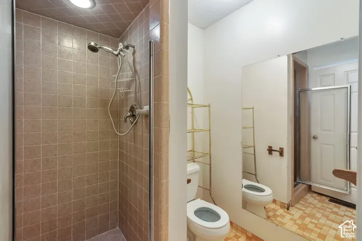 Tiled shower enclosure with a hand-held shower head