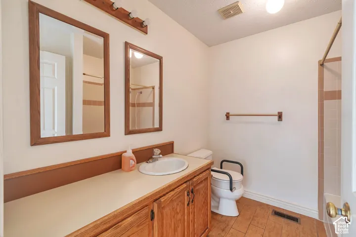 Spacious vanity with an integrated sink, wood-finish cabinetry, and two framed mirrors