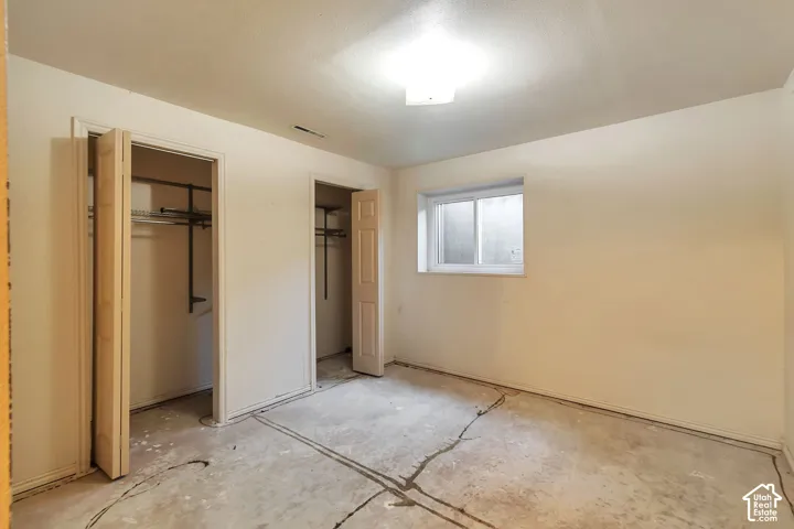 Room with two bi-fold door closets, a single window, and overhead lighting