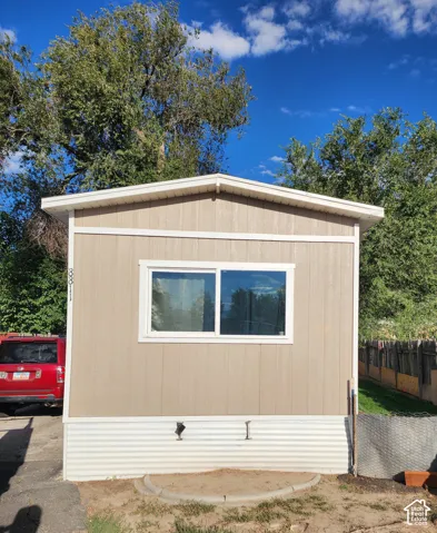 Neutral-toned siding with white trim and a white skirting
