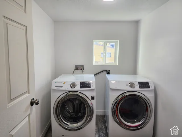 Dedicated laundry space featuring a window, overhead lighting, and wood-finish flooring