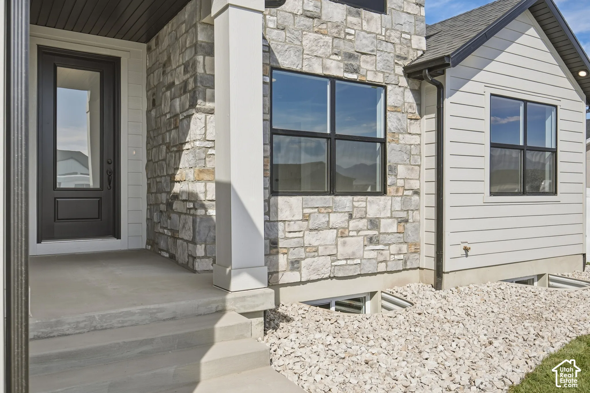 Stone and siding exterior with black-framed windows