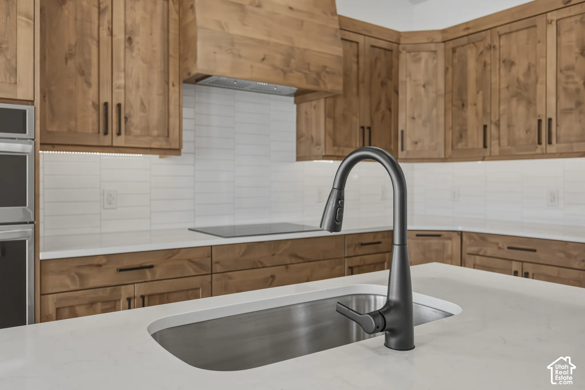 Wood-finish cabinetry with dark hardware and under-cabinet lighting