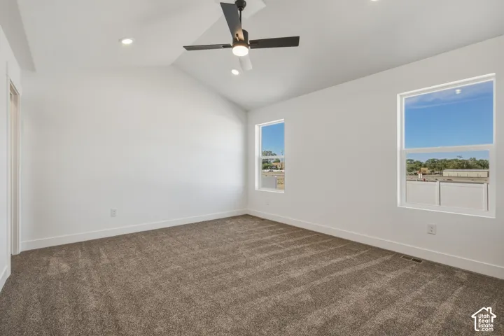 Vaulted ceiling with a contemporary ceiling fan, recessed lighting, and two windows