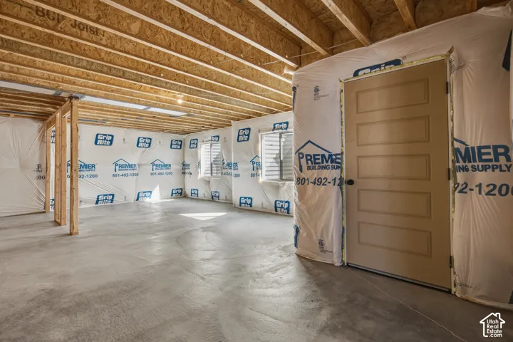 Unfinished basement space featuring exposed wood joists and concrete flooring
