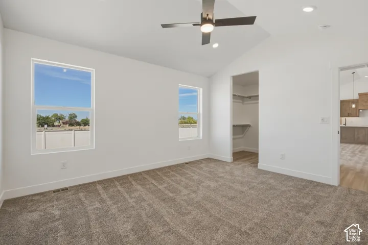 Vaulted ceiling with a contemporary ceiling fan, recessed lighting, and soft carpet flooring