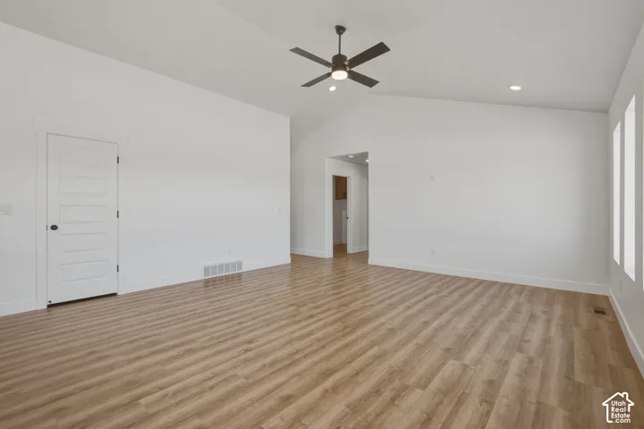 Vaulted ceiling with a ceiling fan, wood-finish flooring, recessed lighting, and white trim