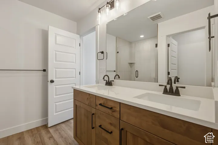 Double vanity with integrated sinks, wood-finish cabinetry, and dark bronze fixtures
