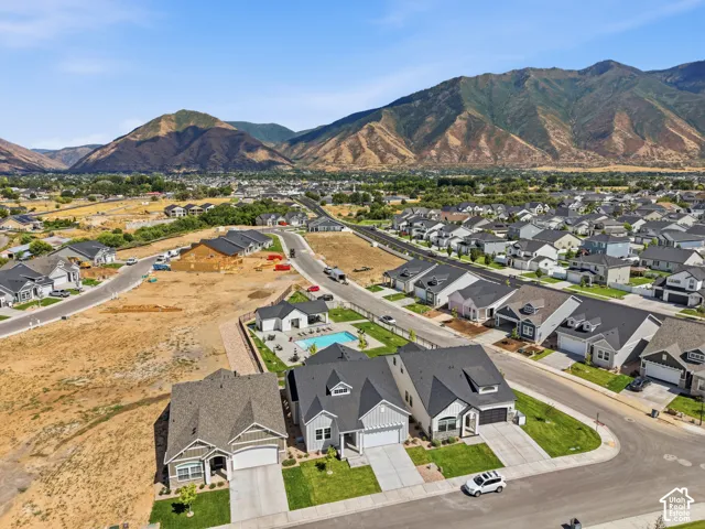 Expansive residential development featuring modern residences, mature landscaping, and mountain scenery