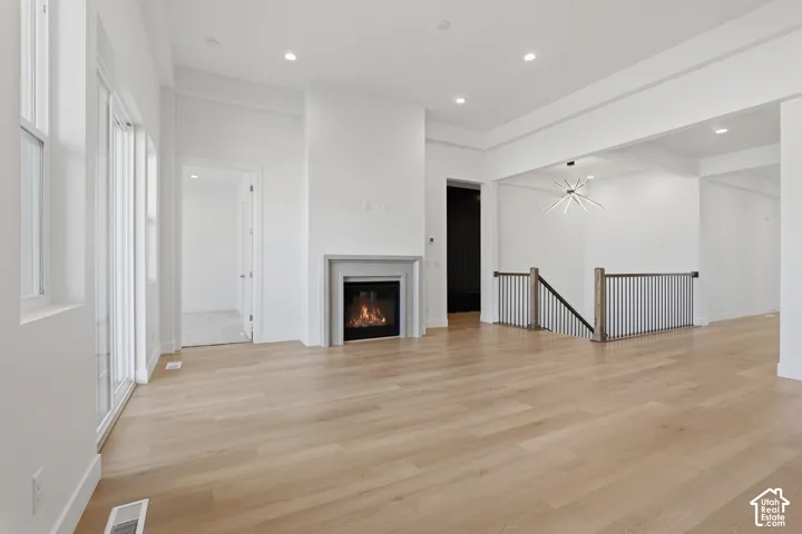 Wood-finish flooring throughout, featuring a modern fireplace with a stone mantel