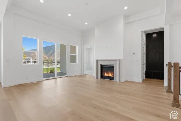 Recessed lighting, wood-finish flooring, built-in fireplace, sliding glass door, and integrated mudroom-style entryway