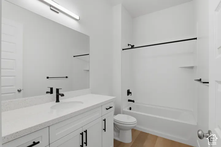 White vanity with a light-toned countertop, rectangular sink, and matte black fixtures