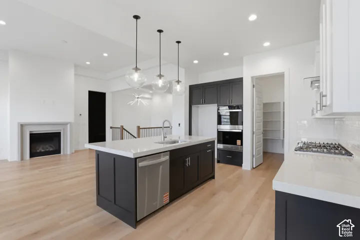 Spacious kitchen featuring an expansive island, stainless steel appliances, a gas cooktop, built-in double ovens, and a walk-in pantry
