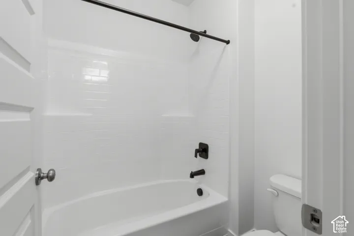 White subway tile shower surround with integrated shelving and matte black fixtures