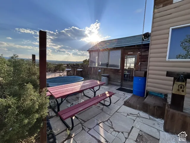 Stone patio with a metal stock tank and a rustic wood exterior