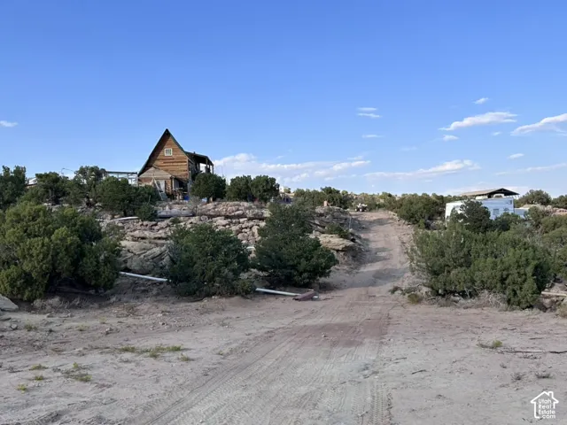 Rustic cabin structure, natural landscaping, and expansive open terrain