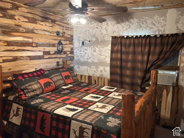 Wood-paneled accent wall, wood-finish ceiling fan, and textured wall treatment