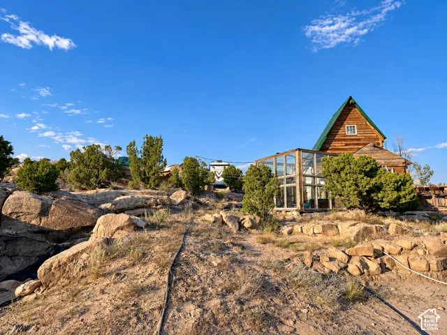 Log-sided exterior with a green metal roof, featuring a gable architectural style